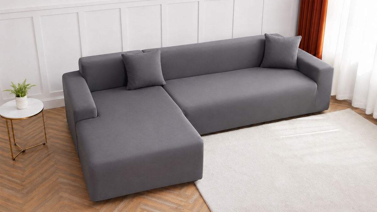 Sofá rinconera gris vestido con fundas, con dos cojines a juego, en un salón con suelo de parqué en punta de Hungría
